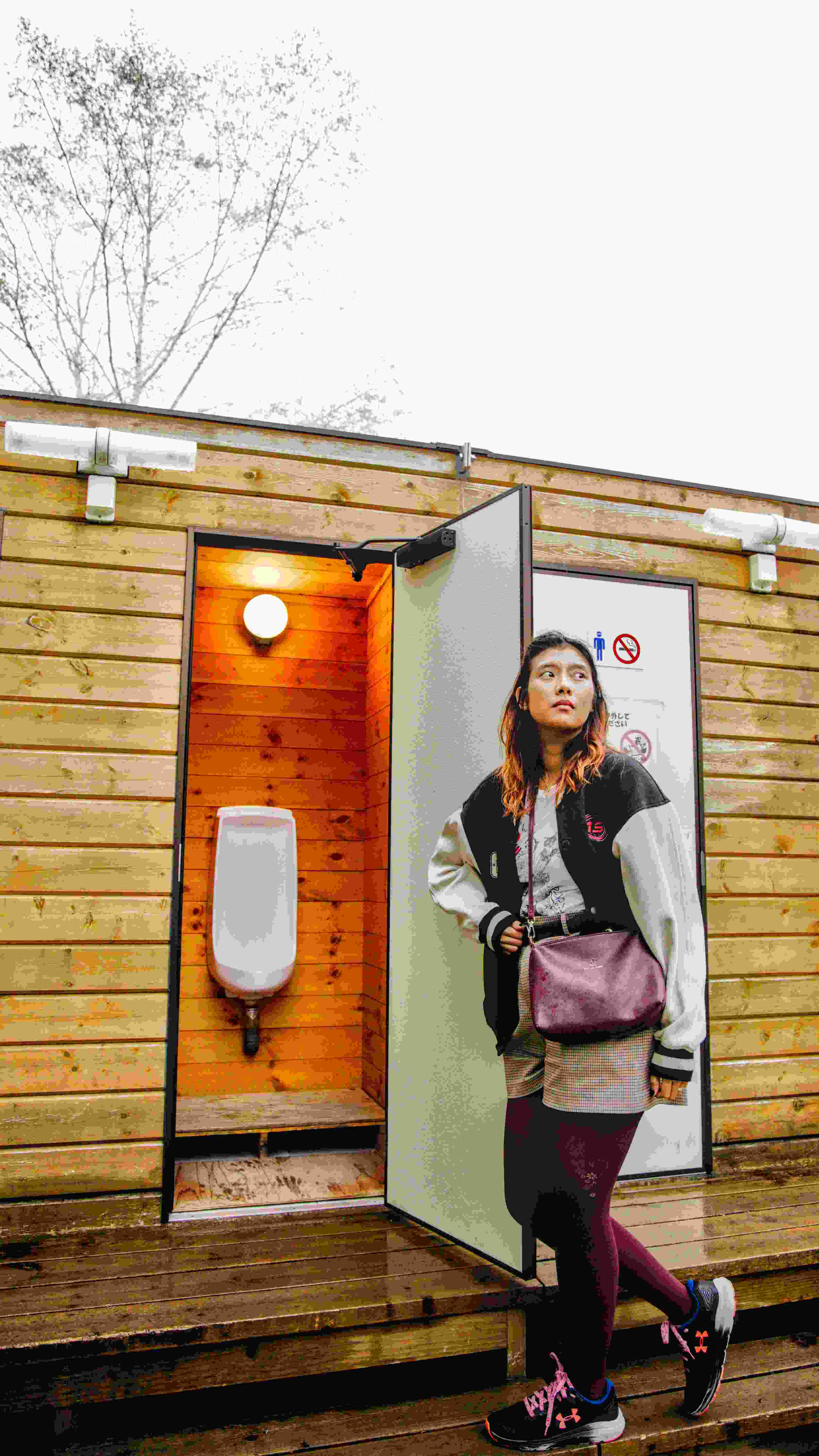 Picture of woman standing next to DAIO International Bio-Toilet urinal.