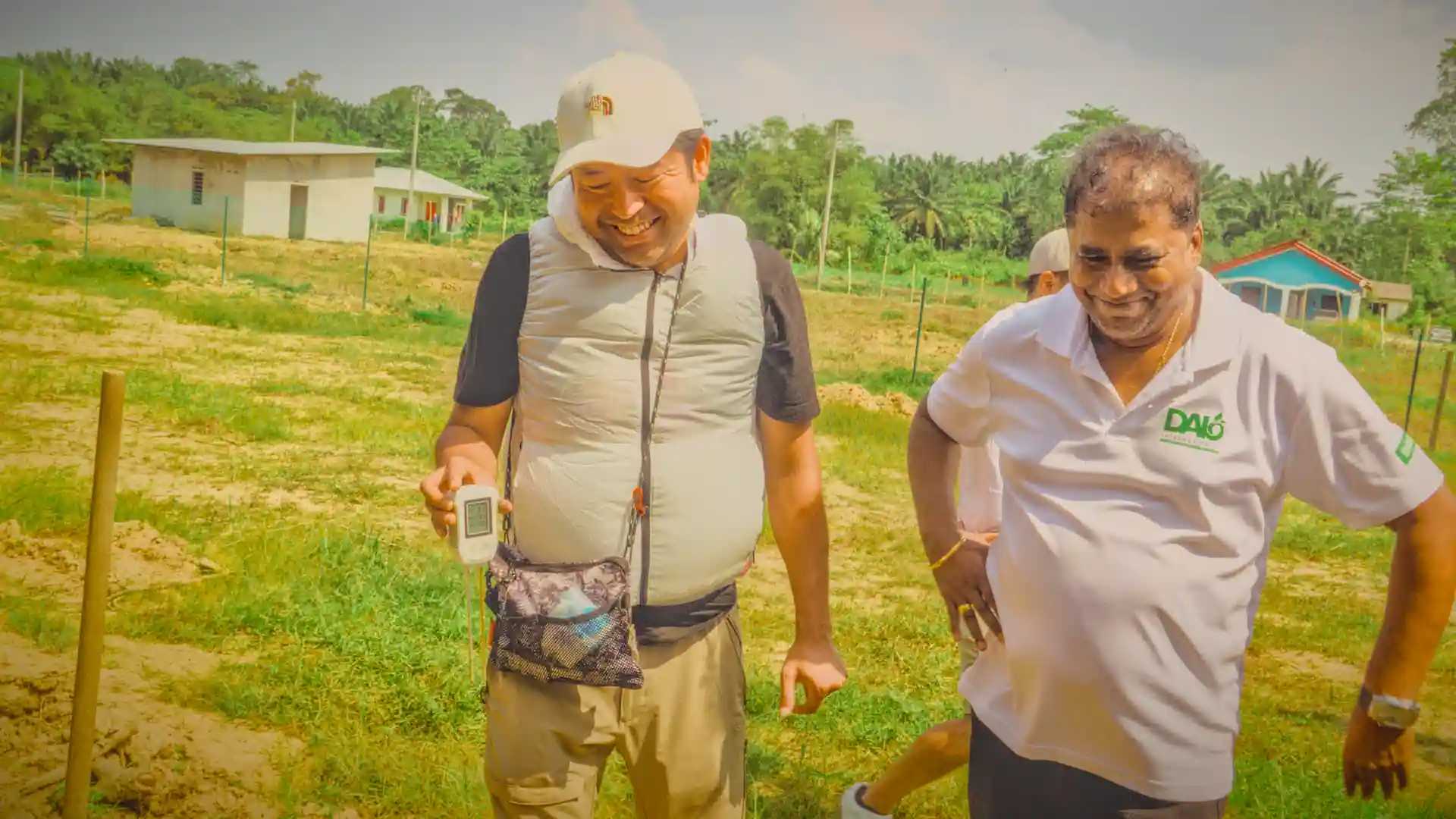 Two men smiling with one holding a pH meter.